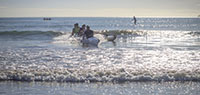 RBOCC Men's Crew Paddling In Surf